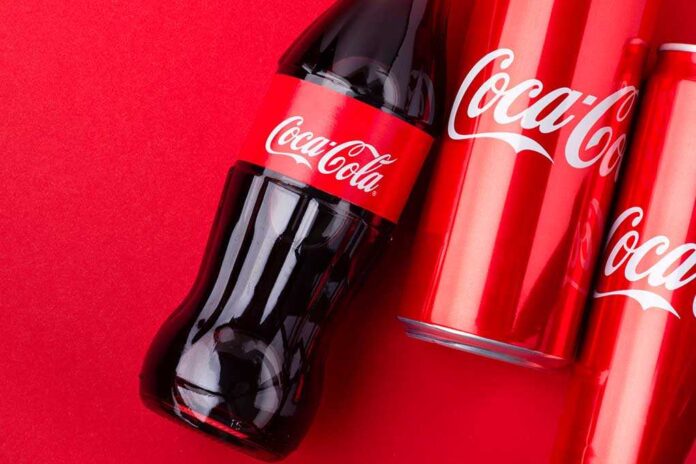 1939159003 featured image Coca-Cola bottles and cans on red background.