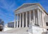 U.S. Supreme Court building with statues and columns.