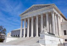 U.S. Supreme Court building with statues and columns.