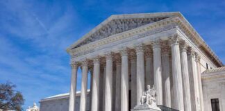 U.S. Supreme Court building with statues and columns.