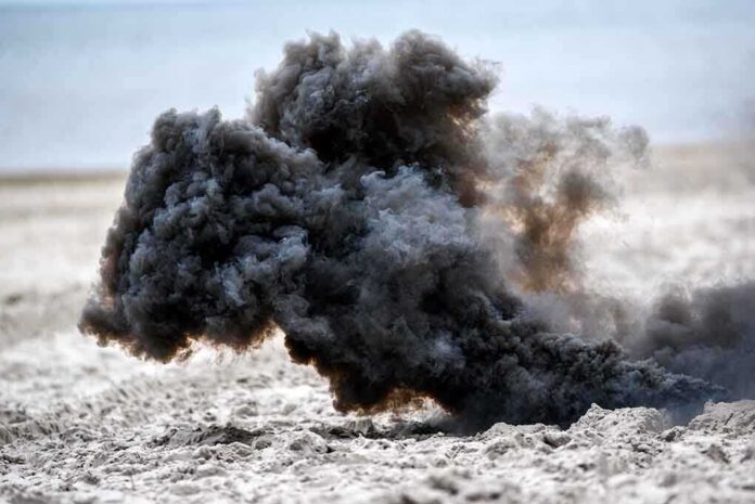 1344342701 featured image Dark smoke cloud rising from sandy beach.