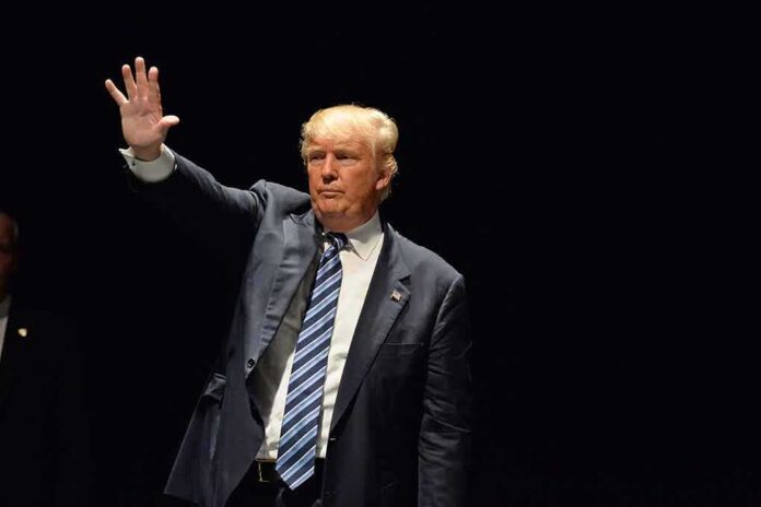 389315509 featured image Man in a suit waving against dark background.