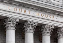 Courthouse facade with four ornate stone pillars