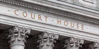 Courthouse facade with four ornate stone pillars