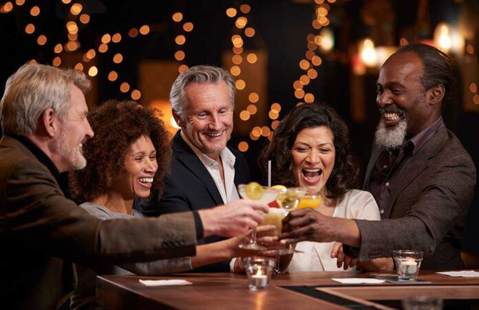 1038716299 featured image People laughing while clinking glasses at a bar