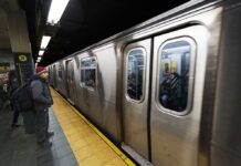 Man waiting at subway platform with departing train