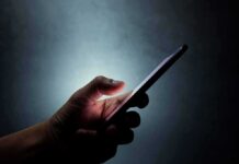 Hand holding a smartphone in the dark