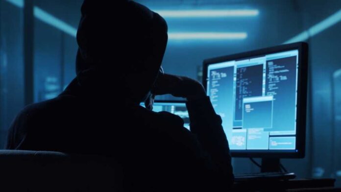 2289453963 featured image Person in hoodie working at computer in dark room