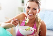 Woman smiling and eating a salad bowl