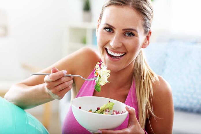 604342055 featured image Woman smiling and eating a salad bowl