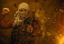 Masked militant holding weapon against fiery background.