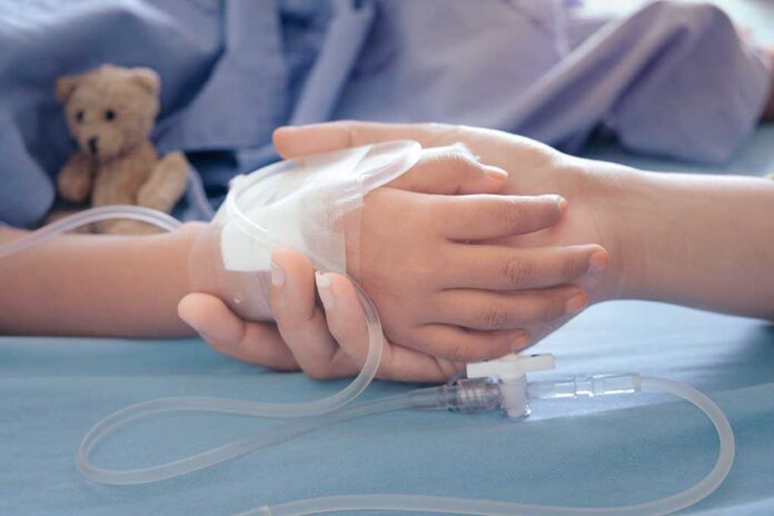 Child's hand with IV held by adult