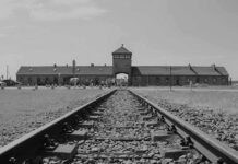 Railroad tracks leading to historical brick building gateway
