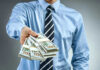 Person handing over a stack of money