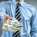 Person handing over a stack of money