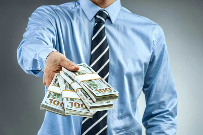 Person handing over a stack of money