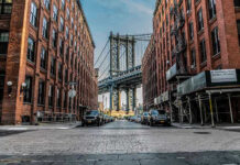 Street view with bridge between two brick buildings