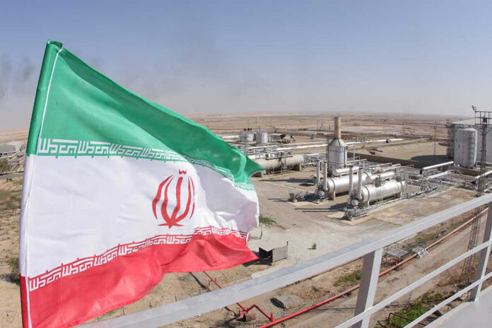 1227310843 Iranian flag near an industrial gas refinery