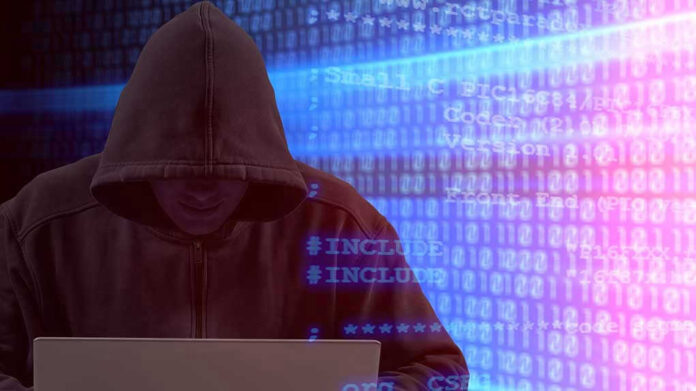 1951632418 Person in hoodie using laptop surrounded by digital code