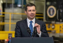 Man in suit speaking at a podium indoors