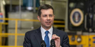 Man in suit speaking at a podium indoors
