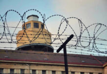 Barbed wire in front of a prison tower
