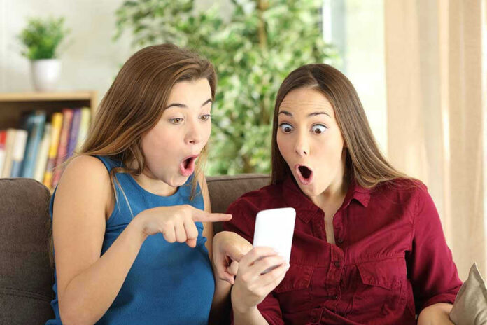 516056992 Two women look surprised at a phone