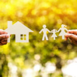 Paper cutouts of a house and family outdoors