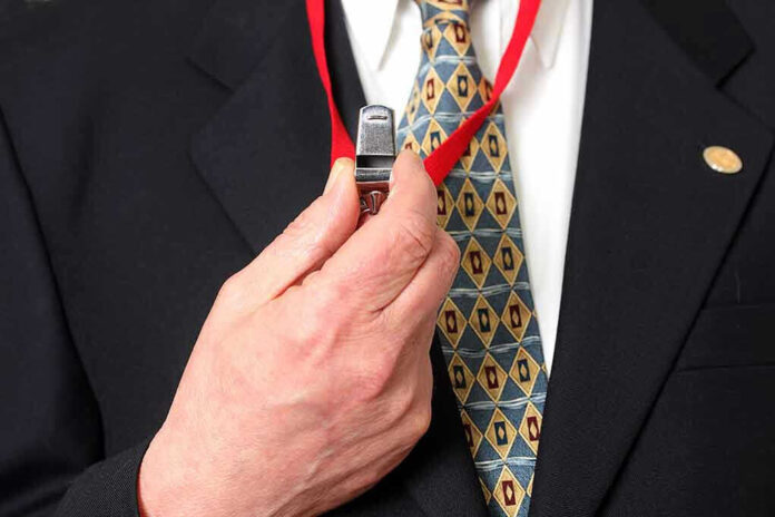 373781791 Person holding a whistle on a red lanyard.