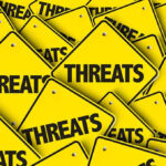 Yellow warning signs with the word "THREATS".