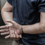 LEGAL Immigrant DETAINED by ICE For 77 Days – Why? Person in handcuffs with hands behind back.