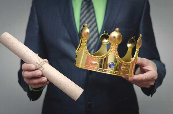 1354280165 Person holding a crown and a scroll