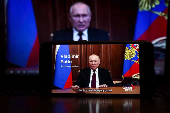 2127643805 Man speaking on screen with Russian flag background