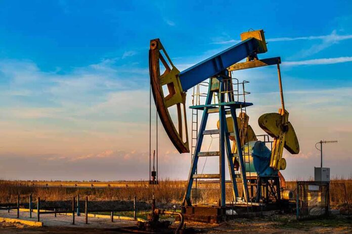 shutterstock_102708536.jpg An oil pump jack operating against a sunset backdrop
