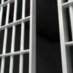 Close-up view of metal prison bars in a dark environment