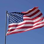 Waving American flag against a clear blue sky