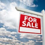Homebuyers Beware: The Silent War You’re Unaware Of A red For Sale sign against a blue sky with clouds