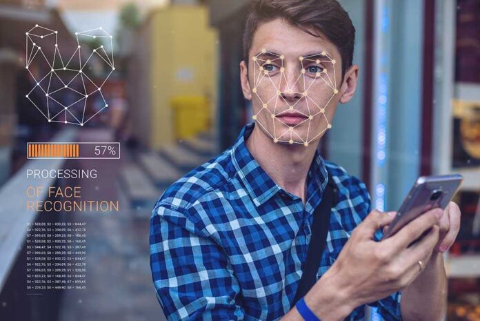 shutterstock_673956757.jpg Young man using a smartphone with face recognition overlay