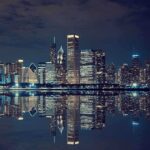 Nighttime view of a city skyline with reflections on water