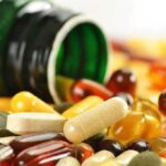 Silent Supplement Danger Targets Your Vital Organs Assorted vitamins and supplements scattered around an overturned bottle