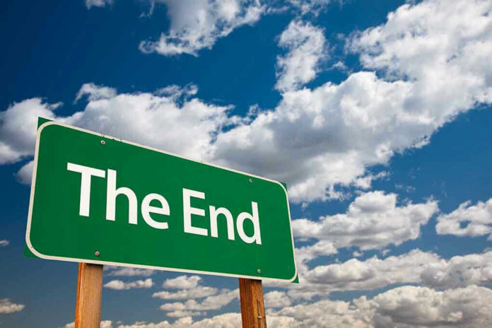 Green sign with white text The End sky background