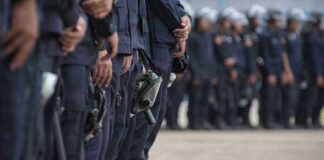 Line of police officers in uniform in formation.