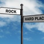GRASSROOTS Initiative FLIPS State Records Directional signpost with ROCK and HARD PLACE labels against a blue sky