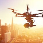 MASSIVE Drone Army Launches Nationwide A drone flying over a city skyline during sunset