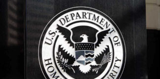 U.S. Department of Homeland Security emblem on wall.