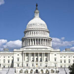 U.S. Capitol building against blue sky.