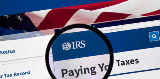 Magnifying glass over IRS website for paying taxes.