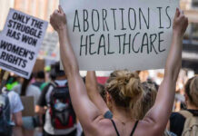 University SLAMMED For Teenage Abortion Event Protestors holding signs about womens rights and healthcare.