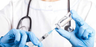 What They Are Making Ebola Vaccine With INFURIATES! Doctor filling syringe with vaccine from vial.