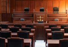 Empty courtroom with wooden benches and judges bench.